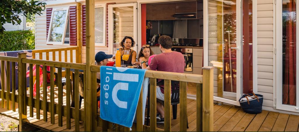 Famille déjeune sur la terrasse de son Mobil home